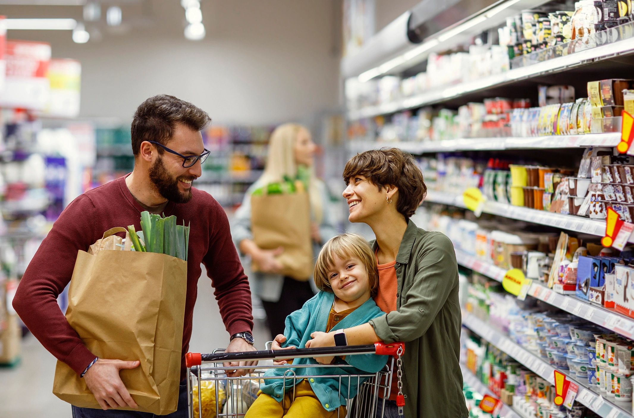 Family shopping together with child in grocery cart